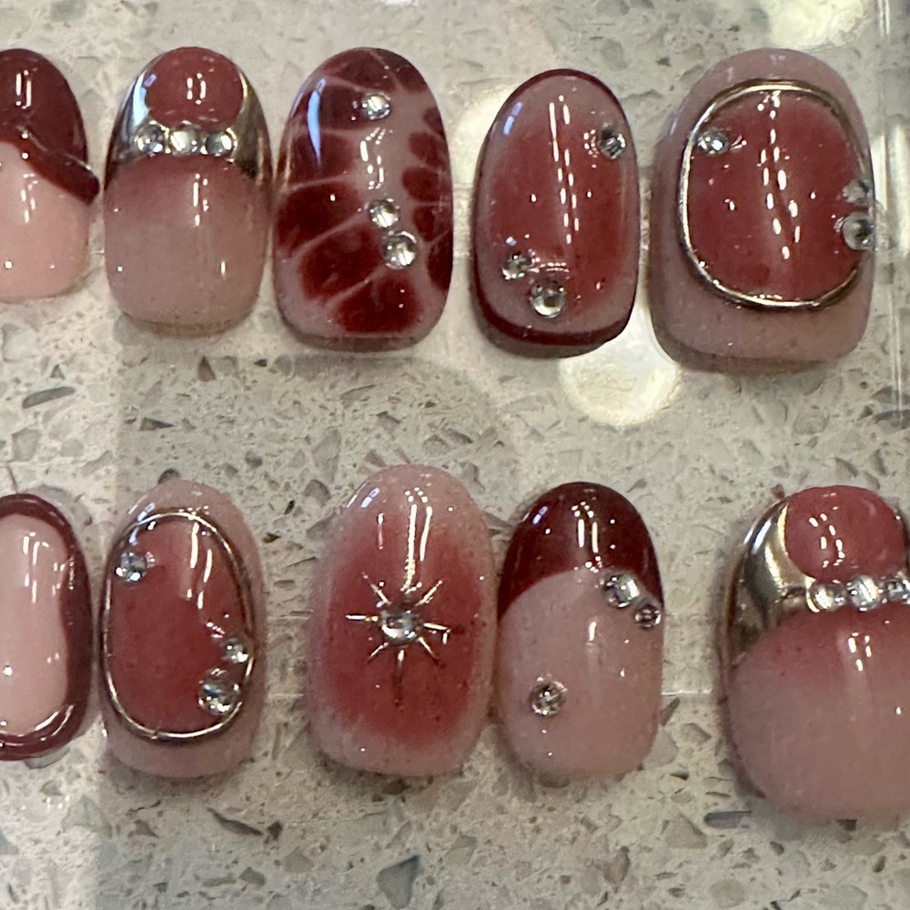 Burgundy and pink press on nails. Short oval shape.